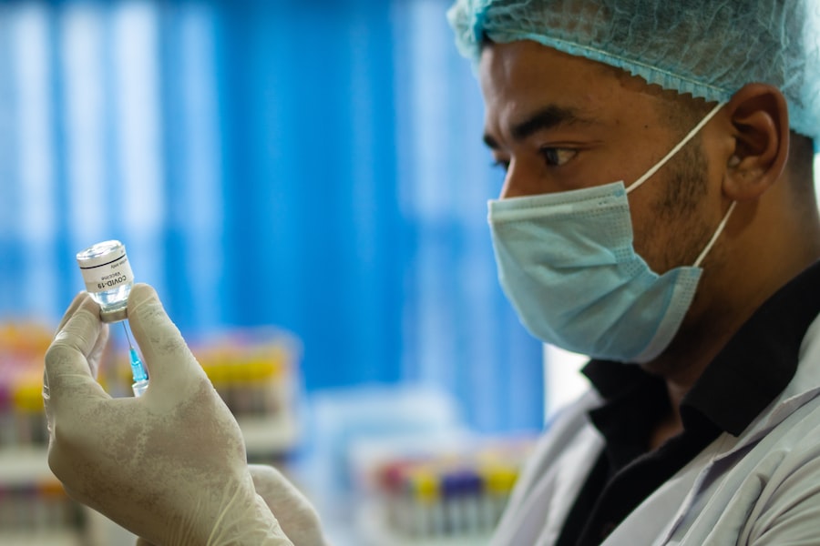  A Person Wearing A Mask And Gloves Holding A Vaccine 
