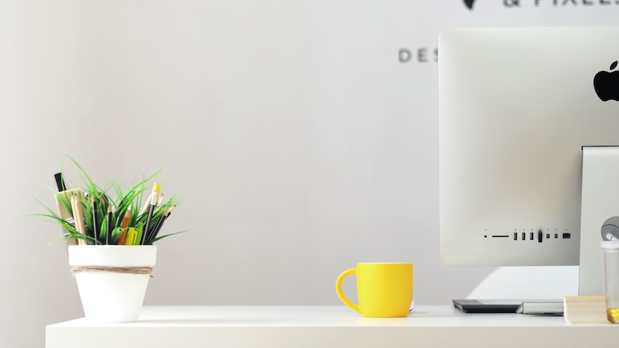 A Desk With A Computer Cup And Other Things 
